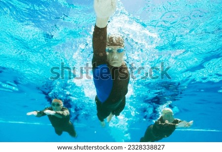 Low angle view triathletes in wetsuits underwater
