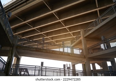 Low angle view of underneath highway bridge and pedestrian footpath