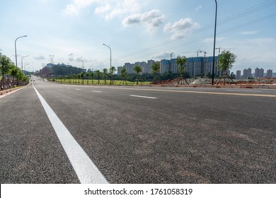 Low Angle View Of Urban Suburban Asphalt Road And Buildings