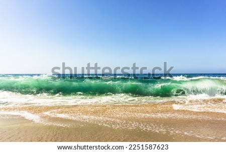 Low angle view of wave crashing onto sandy beach