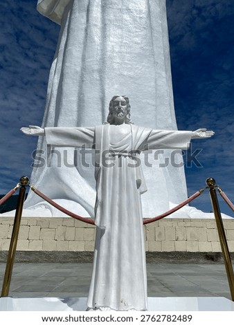 Low angle view of a white statue of Jesus Christ with outstretched arms at Sibea-bea Hill, Samosir, North Sumatra, Indonesia. This iconic religious landmark stands tall overlooking the scenic Lake Toba area, attracting tourists and pilgrims. The statue is part of a religious tourism destination known for its spiritual atmosphere and panoramic natural landscape.