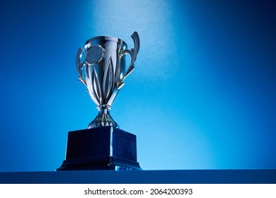 low angle view of winning trophy against blue background - Shutterstock ID 2064200393