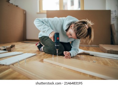 Low angle view of woman assembling furniture at home  - Powered by Shutterstock