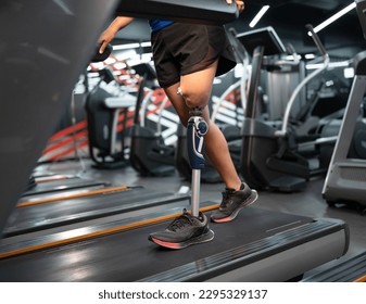 Low angle view at woman with prosthetic leg walking in treadmill at fitness gym	 - Powered by Shutterstock