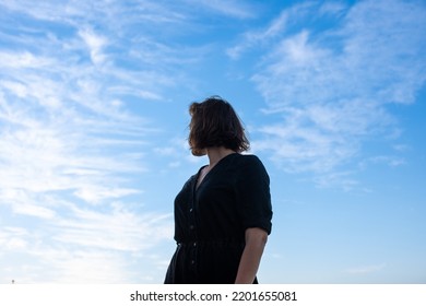 Low angle view of woman standing and looking back