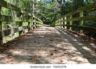 A Low Angle View Of The Wood Bridge With The Autumn Leaves On The Bridge.