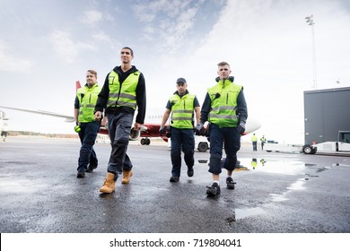Low Angle View Of Workers Walking On Runway