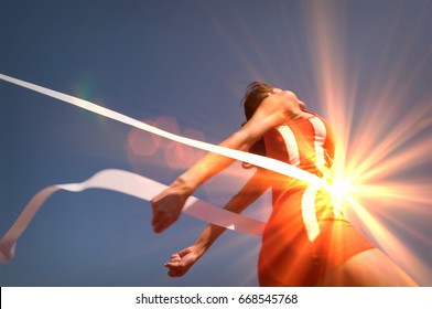 Low angle view of young female athlete crossing finish line against clear blue sky - Shutterstock ID 668545768