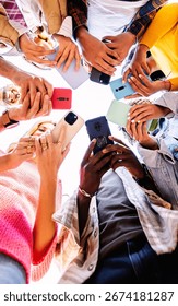 Low angle view of young group of student people using smart phones together outside. Social media and communication lifestyle concept