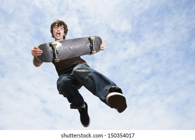 Low Angle View Of Young Man Performing Trick On Skateboard