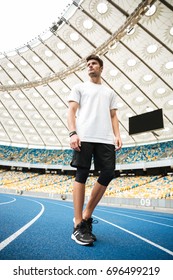 Low Angle View Of A Young Sportsman Walking On A Racetrack At The Stadium