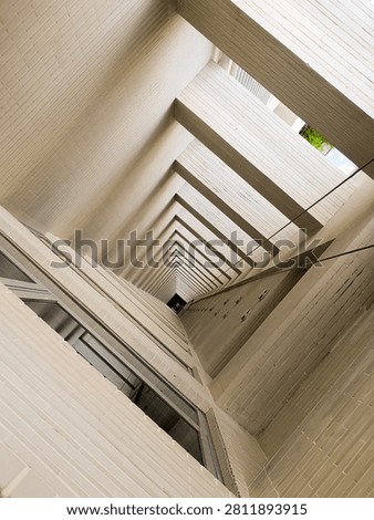 Low angle worm's-eye view of a modern building's ventilation shaft, showing clean geometric lines, white tiled walls, and a dramatic vanishing point perspective.