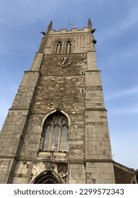 Low angled picture of a UK church tower taken late on a summers afternoon with clock face on tower