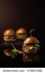 A Low Angled Shot Of Three Vegan Bahn Mi Sliders On A Dark Background.