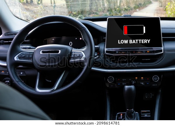 Low battery warning in\
electric car. Red indicator on display. battery icon on plug in\
hybrid car.