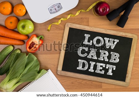 LOW CARB DIET Fitness and weight loss concept, dumbbells, white scale, fruit and tape measure on a wooden table, top view, free copy space