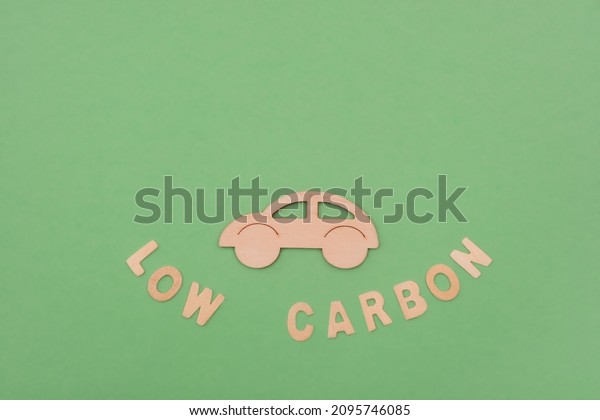 Low carbon
delivery concept, eco transport, vehicle. Wooden letters on green
background, flatly.Top view, copy
space.
