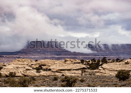 Low Clouds Spill Over The White Rim in Canyonlands National Park