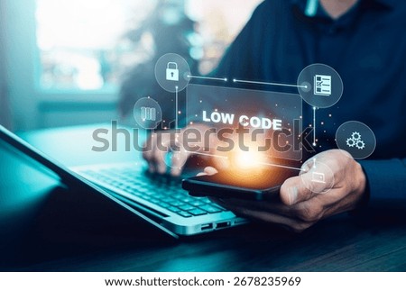 Low code development concept with businessman using laptop and smartphone. Digital interface icons show modern software, automation, app creation, innovation, and IT solutions.