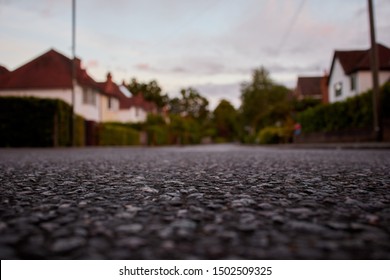 Low down view of an empty road in England with houses either side.                               