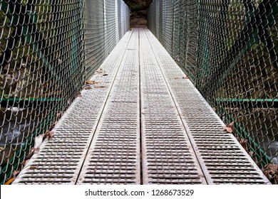 A Low Downward-angle View With Extreme Symmetry Of A Metal Footbridge Over The Little Gizzard Creek Just Upstream Foster Falls In Sequatchie Tennessee.