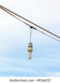 Low energy light bulb hanging in wires outside