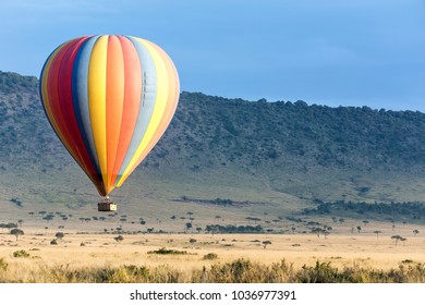 Low Flying Colourful Balloon Over The Grasslands Of The Masai Mara. No Recognizable People Visible. 