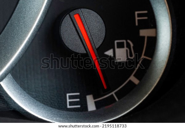 Low fuel gauge on\
car dashboard, close-up.