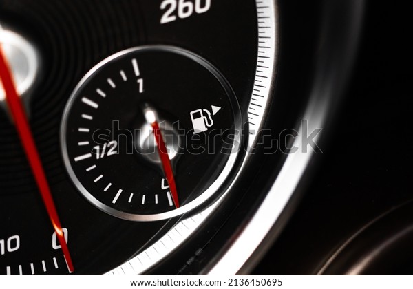Low fuel gauge showing fuel dashboard, glowing\
indicator, close-up 