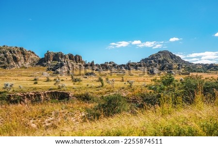 Low grass growing on African savanna, small rocky mountains in background - typical scenery at Isalo national Park, Madagascar