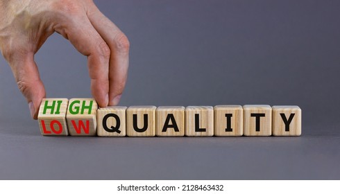 Low or high quality symbol. Businessman turns cubes and changes words low quality to high quality. Beautiful grey table grey background. Business low or high quality concept, copy space.