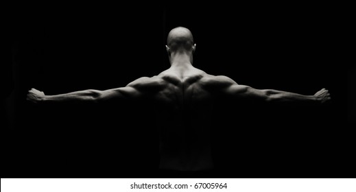 Low key artistic strong man on a black background - Powered by Shutterstock