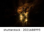 low key image of beautiful kings crown over wooden table. vintage filtered. fantasy medieval period. Selective focus. Colorful backlight