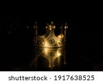 low key image of beautiful queen (or king) crown over wooden table. vintage filtered. fantasy medieval period. Selective focus. Colorful backlight