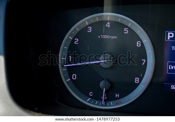 low key\
image of a cars purple and grey\
tachometer.