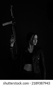 Low Key Portrait Of Woman With Machine Gun