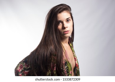 Low Key Portrait Of A Young Girl With A Sexy Nightgown Looking To The Camera Dissapointed On White Background. Sexual And Couple Problems, Erectile Disfunction And Lack Of Female Satisfaction Concept.