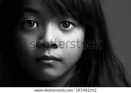 Low key shot of little asian girl in black & white