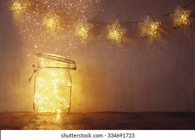 low key and vintage filtered image of fairy lights in mason jar with. selective focus. glitter overlay  - Powered by Shutterstock