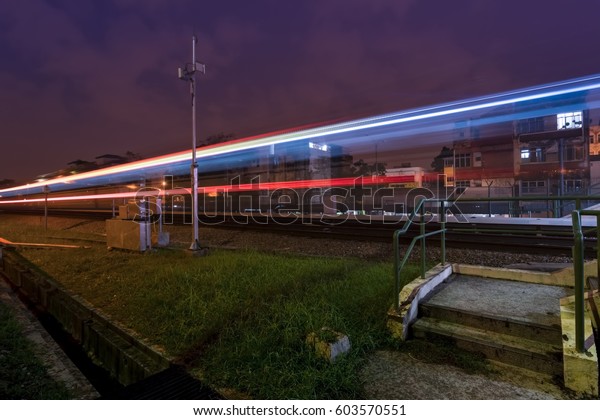 Low light photography of light trail monorail\
train at station railway