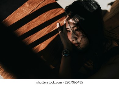 low light under exposure close up woman photo portrait. leaning on the table with confused expression and think something - Powered by Shutterstock