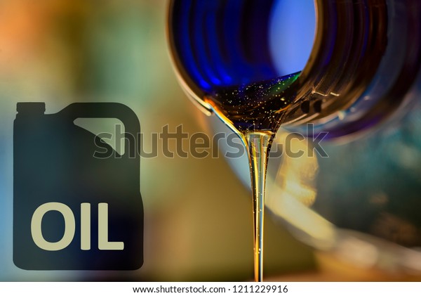 Low oil problem and\
liquid stream of motorcycle motor oil flows from the neck of the\
bottle close-up.