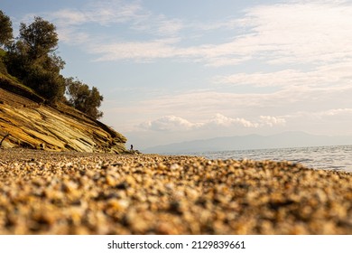 Low Perspective Of Beach View.Greek Empty Beach With Rock And Forest View.