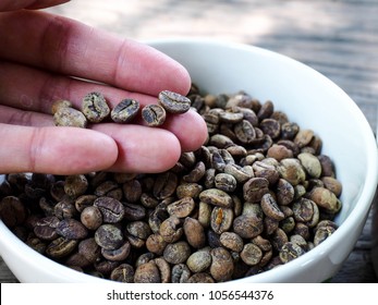 Low quality raw coffee beans. Coffee bean with defect, low grade.

