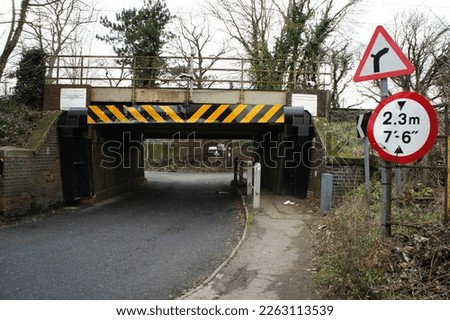 A low railway bridge and narrow road, Needham Market,  Suffolk, England, UK. In 2020 2021 this bridge was subject to 19 bridge strikes. The height sign is now no longer on the bridge but at the side.