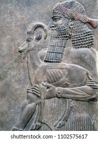 Low relief stone carving depicting an ancient man holding a sheep