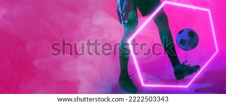 Low section of caucasian male player playing with ball by illuminated hexagon on pink background. Copy space, composite, sport, soccer, competition, neon, illustration, smoke, glowing and abstract.
