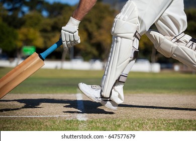 Low section of cricket player scoring run on field during sunny day - Powered by Shutterstock