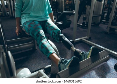 Low Section Of Disabled Active Senior Caucasian Woman With Leg Amputee Exercising With Leg Press Machine In Fitness Studio. Strong Active Senior Female Amputee Training And Working Out