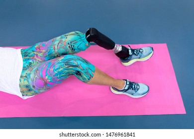 Low section of disabled Caucasian active senior woman exercising on exercising mat in sports center. Sports Rehab Centre with physiotherapists and patients working together towards healing - Powered by Shutterstock